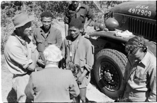 Group of people talking with L. F. Maingard, preparation for a recording