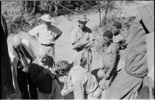 Group of people talking with L. F. Maingard, preparation for a recording