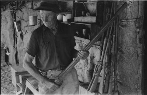 Thomas Hardbattle in his store-room holding a gun