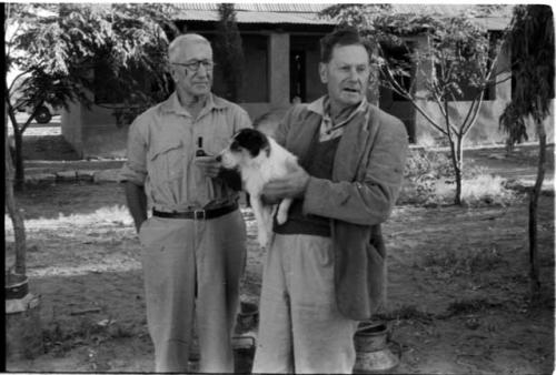 Frank and Bert Ramsden standing, with Bert holding their little dog