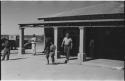 Theunis Berger leaving a store, and people walking in front of it