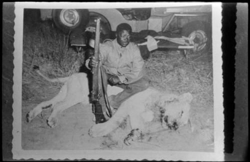 Philip Hameva with dead lion and holding a gun (copy of Polaroid photograph)