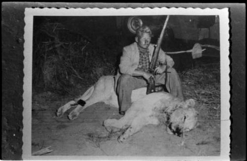 Theunis Berger with dead lion and holding a gun (copy of Polaroid photograph)