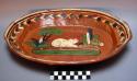 Flat-bottomed dish, buff clay. red-brown glaze with polychrome design