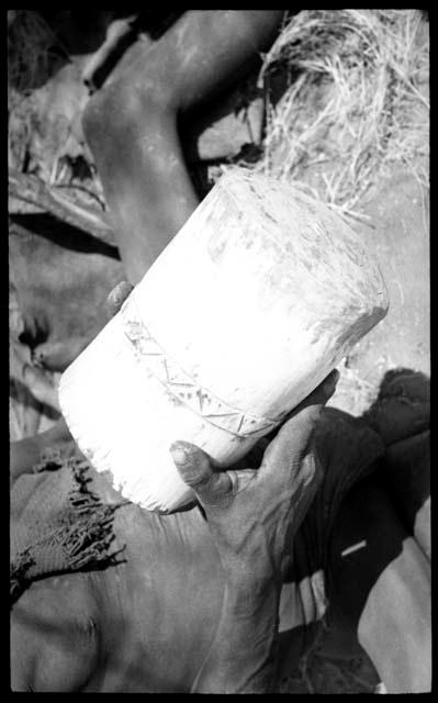 Person's hands holding a mortar, close-up