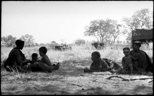 Khuan//a sitting to the left with her sons, ≠Toma and /Qui, "Old /Gasa" lying down, and an unidentified woman and girl sitting to the right