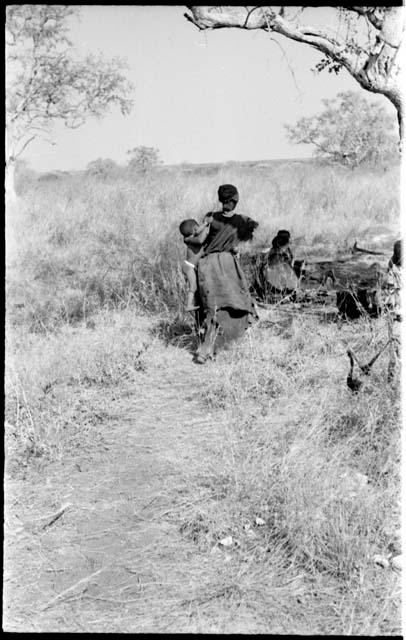 Di!ai seen from the back, carrying Debe against her side