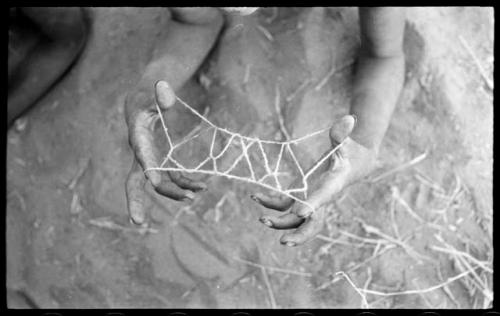 Child's hands holding a "cat's cradle"