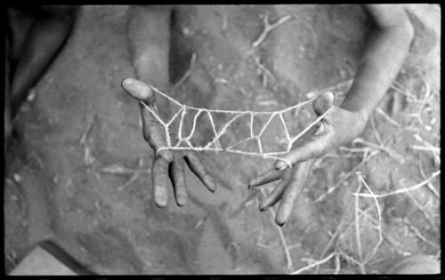 Child's hands holding a "cat's cradle"