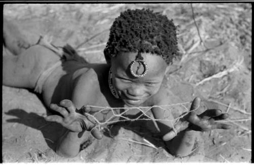 Child holding a "cat's cradle"