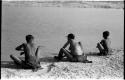 Three women bathing, seen from behind