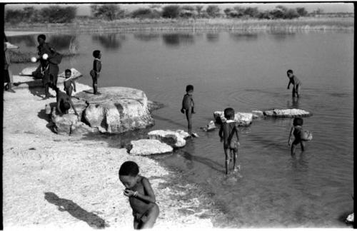 Children playing in the water and people on the shore