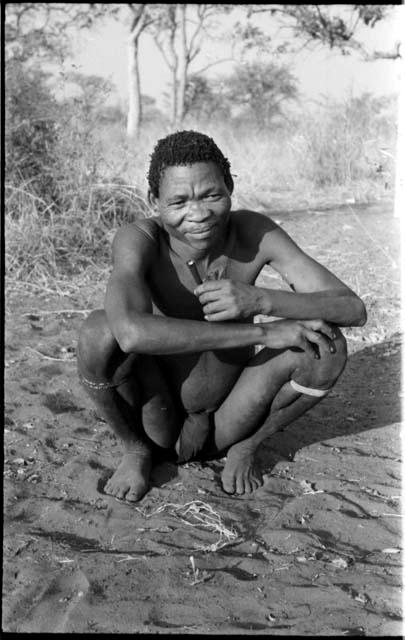 "/Qui Navel" squatting and holding a metal pipe