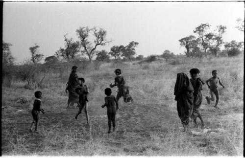 Girls playing N!owa t/ama (melon tossing game) / tamah n!o’an (ball game); other children present in the background