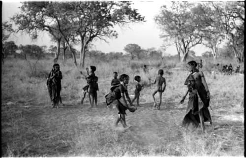 Girls playing N!owa t/ama (melon tossing game) / tamah n!o’an (ball game); other children present in the background