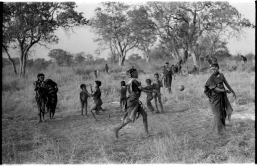 Girls playing N!owa t/ama (melon tossing game) / tamah n!o’an (ball game); other children present in the background