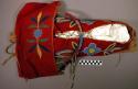 Cradle attached to cradle board--beaded decoration on red wool cover
