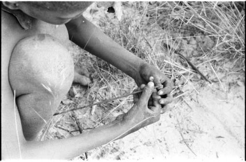 !Oukabe crouched, holding a stick in his hands, close-up