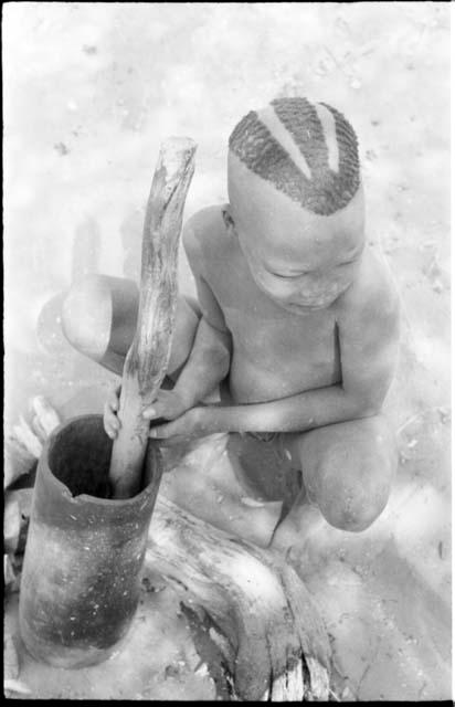 "Visiting boy" pounding something in mortar with pestle