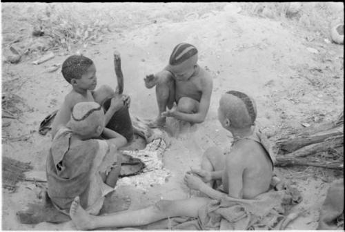 Boys of Oukwane's group and "visiting group" sitting by a fire