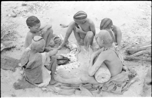 Boys of Oukwane's group and "visiting group" sitting by a fire