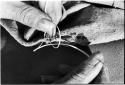 Person sewing, close-up of hands making knot