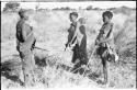 Three women standing in their veld, holding their digging sticks