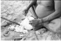 Close-up of Oukwane's hands scraping a water root