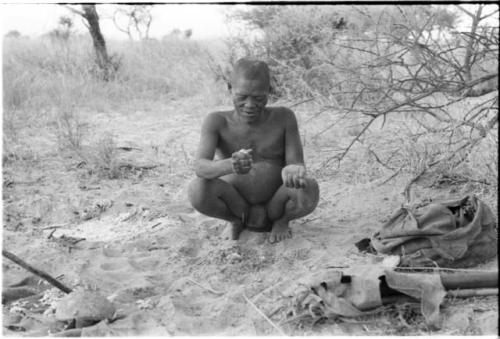 Oukwane squatting in werft while squeezing juice