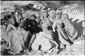 Group of visitors sitting in a cluster, wrapped in karosses