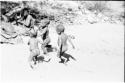 Three little boys running in the sand