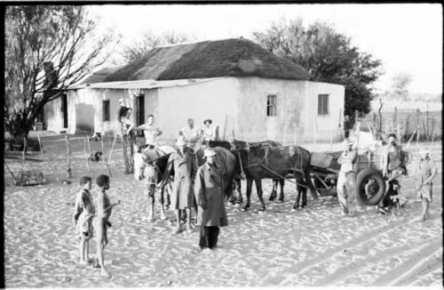 Theunis Berger's house with a group of people, including Theunis Berger and Marguerita Ammann, gathered in the foreground