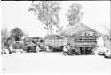 Expedition's trucks off-loading at one of its camps beside a hut