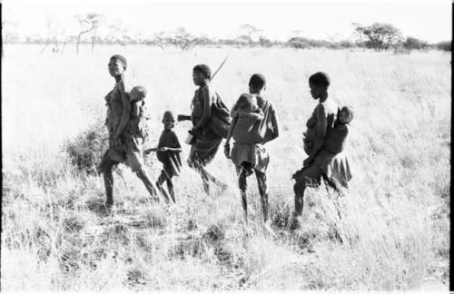 Group of women walking in grass with their children