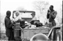 Laurence Marshall and Lorna Marshall sitting in the expedition Jeep, with two men present