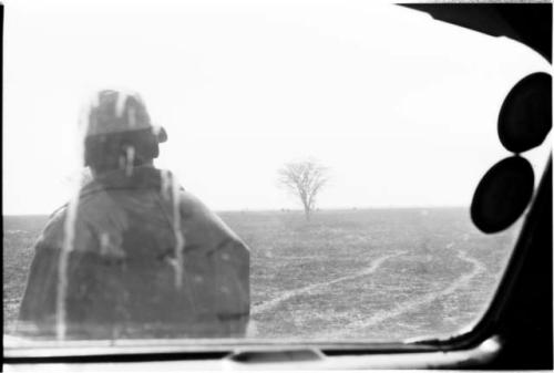 Man standing before a truck window, seen from behind