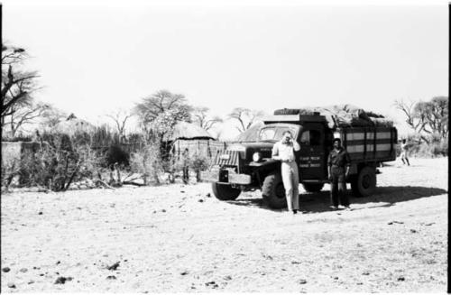 William Donnellan and Kernel Ledimo standing in front of the expedition truck, with huts in the background