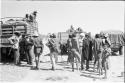 People standing next to expedition members near trucks