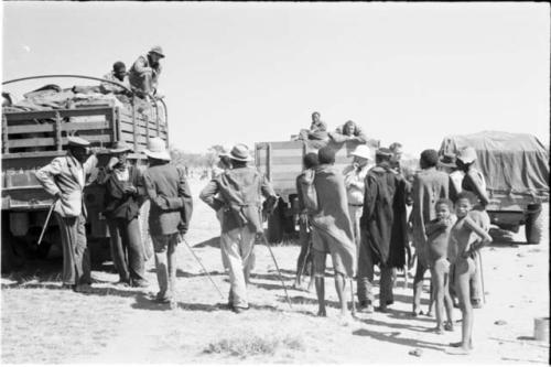 People standing next to expedition members near trucks