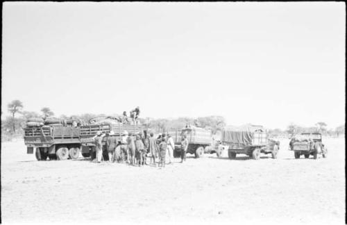 People standing next to expedition members near trucks