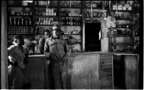 Interior of a trader's store at Sehitwe, with three men standing