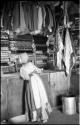 Interior of a trader's store at Sehitwe, with a woman looking at items