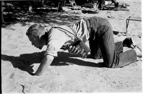 John Marshall kneeling in the sand