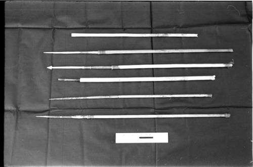 Six arrows on a black background with a ruler for measurement