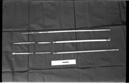 Three arrows against a black background with a ruler for measurement; shows bone point, connecting link, and shaft separated