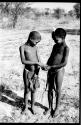 Two children passing something in their hands