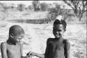 Two children passing something in their hands