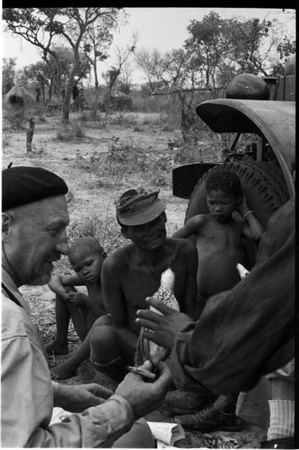 "/Gao Overalls" and two boys sitting, with O.P.M. Prozesky and a person's hand holding a bird