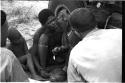 "/Gao Overalls" holding a bird sitting next to a boy with O.P.M. Prozesky and Nicholas England sitting across from him, seen from behind