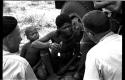 "/Gao Overalls" holding a bird sitting next to a boy with O.P.M. Prozesky and Nicholas England sitting across from him, seen from behind